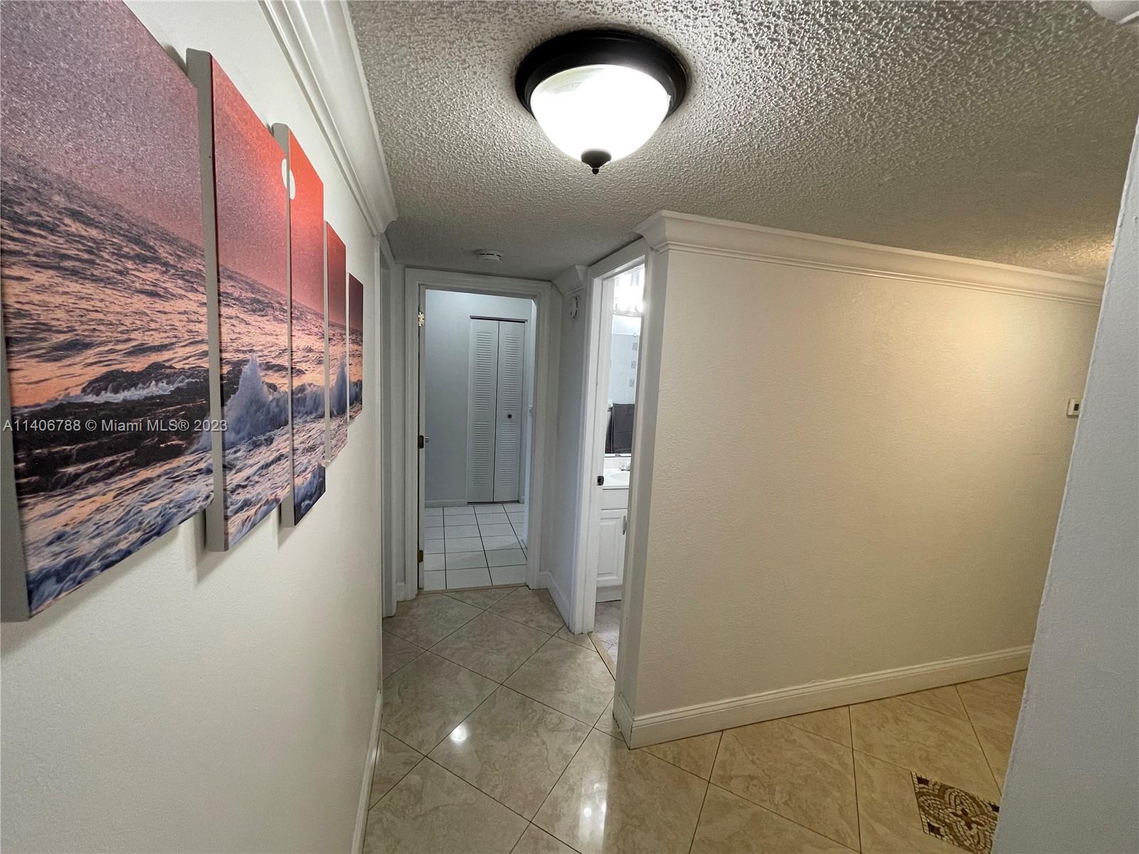 6861 Southwest 147th Avenue, Unit 2G Miami, FL 33193 - Photo 13 of 34 a view of a hallway with wooden floor and a bathroom