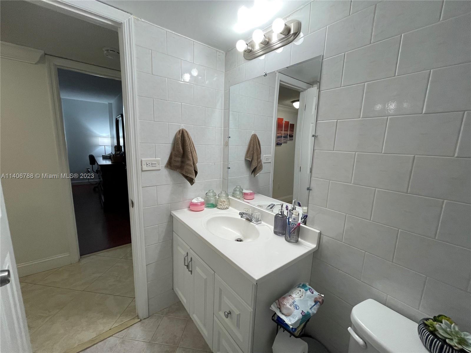 6861 Southwest 147th Avenue, Unit 2G Miami, FL 33193 - Photo 15 of 34 a bathroom with a sink vanity and a mirror