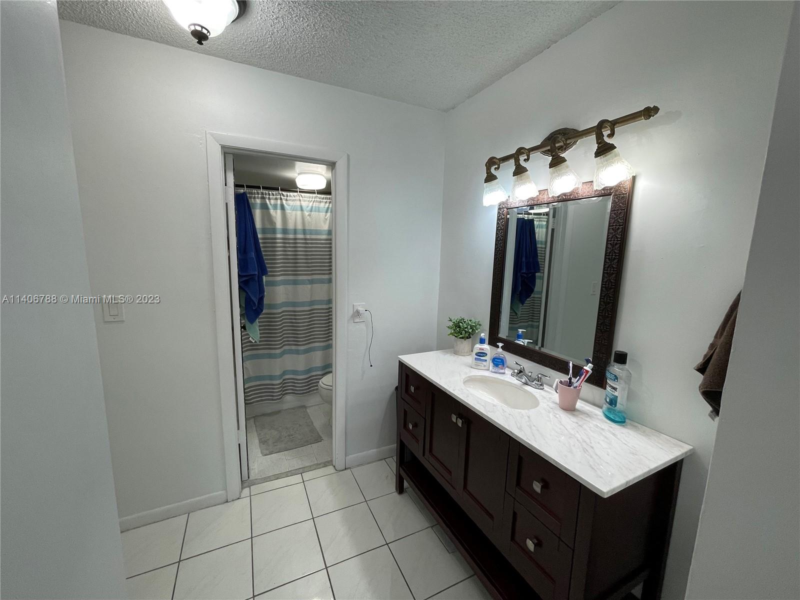 6861 Southwest 147th Avenue, Unit 2G Miami, FL 33193 - Photo 21 of 34 a bathroom with a sink vanity and a mirror