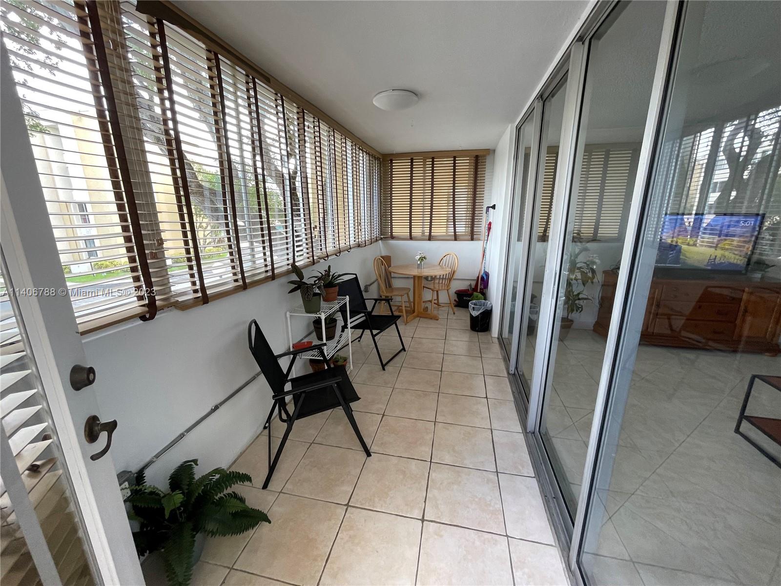 6861 Southwest 147th Avenue, Unit 2G Miami, FL 33193 - Photo 27 of 34 a living room with furniture and a floor to ceiling window