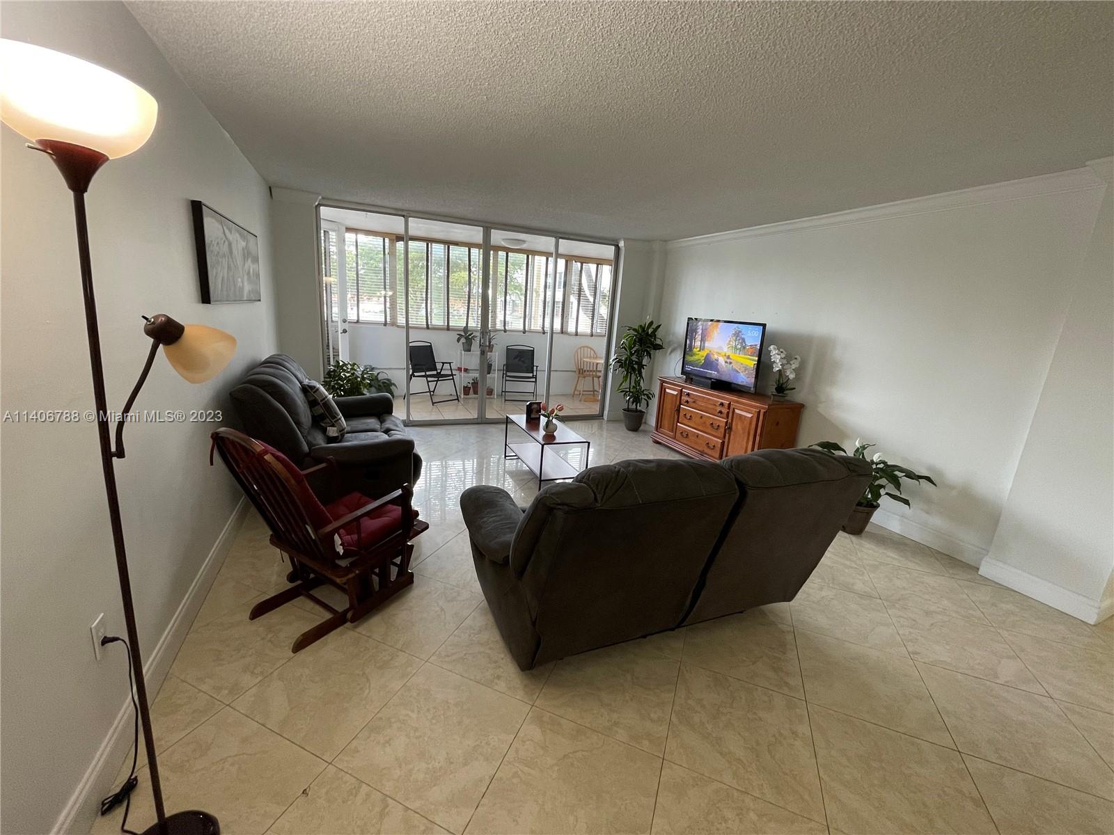 6861 Southwest 147th Avenue, Unit 2G Miami, FL 33193 - Photo 28 of 34 a living room with furniture and a flat screen tv