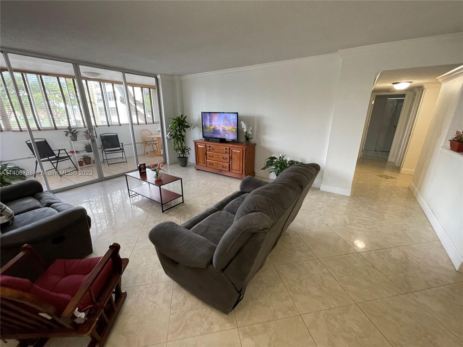 6861 Southwest 147th Avenue, Unit 2G Miami, FL 33193 - Photo 29 of 34 a living room with furniture and a flat screen tv