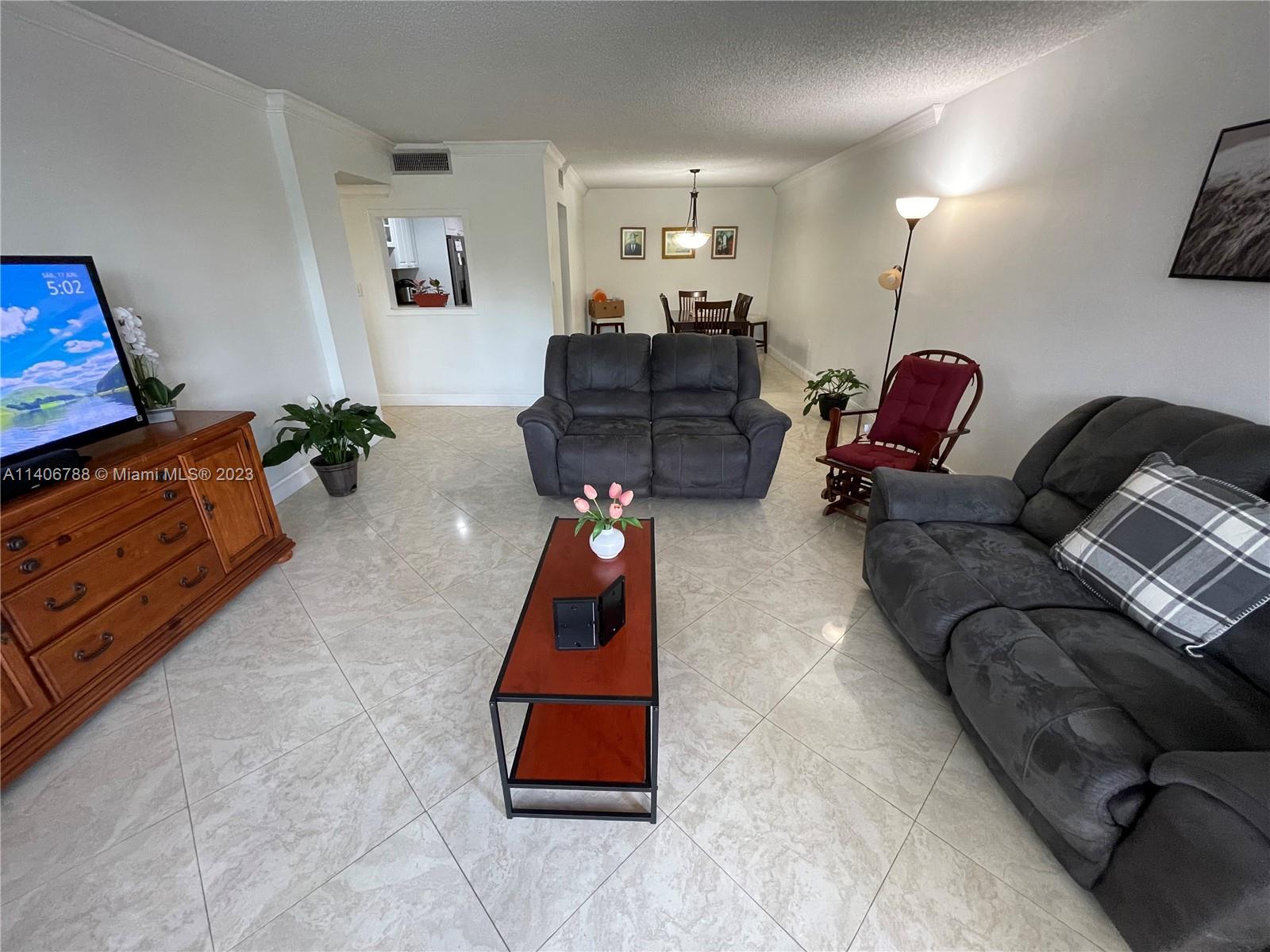 6861 Southwest 147th Avenue, Unit 2G Miami, FL 33193 - Photo 5 of 34 a living room with furniture gym equipment and a lamp