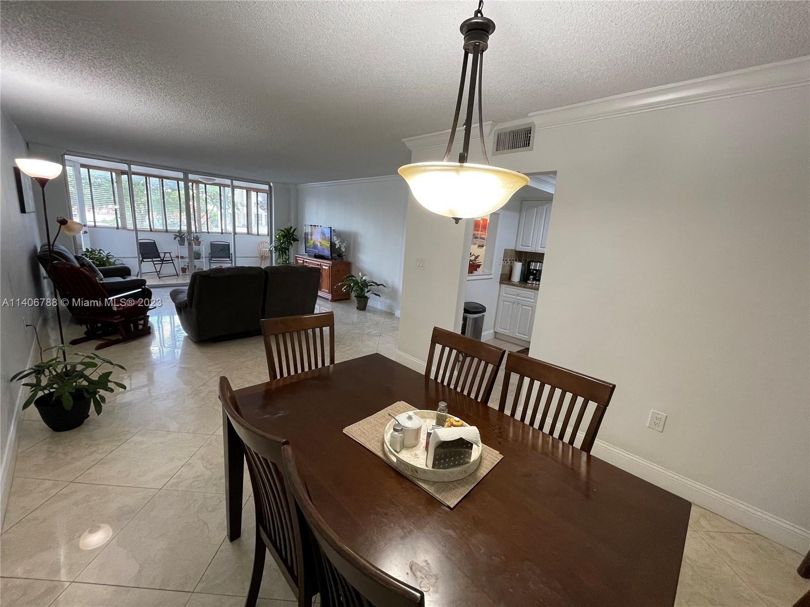 6861 Southwest 147th Avenue, Unit 2G Miami, FL 33193 - Photo 6 of 34 a view of a dining room with furniture a rug and wooden floor
