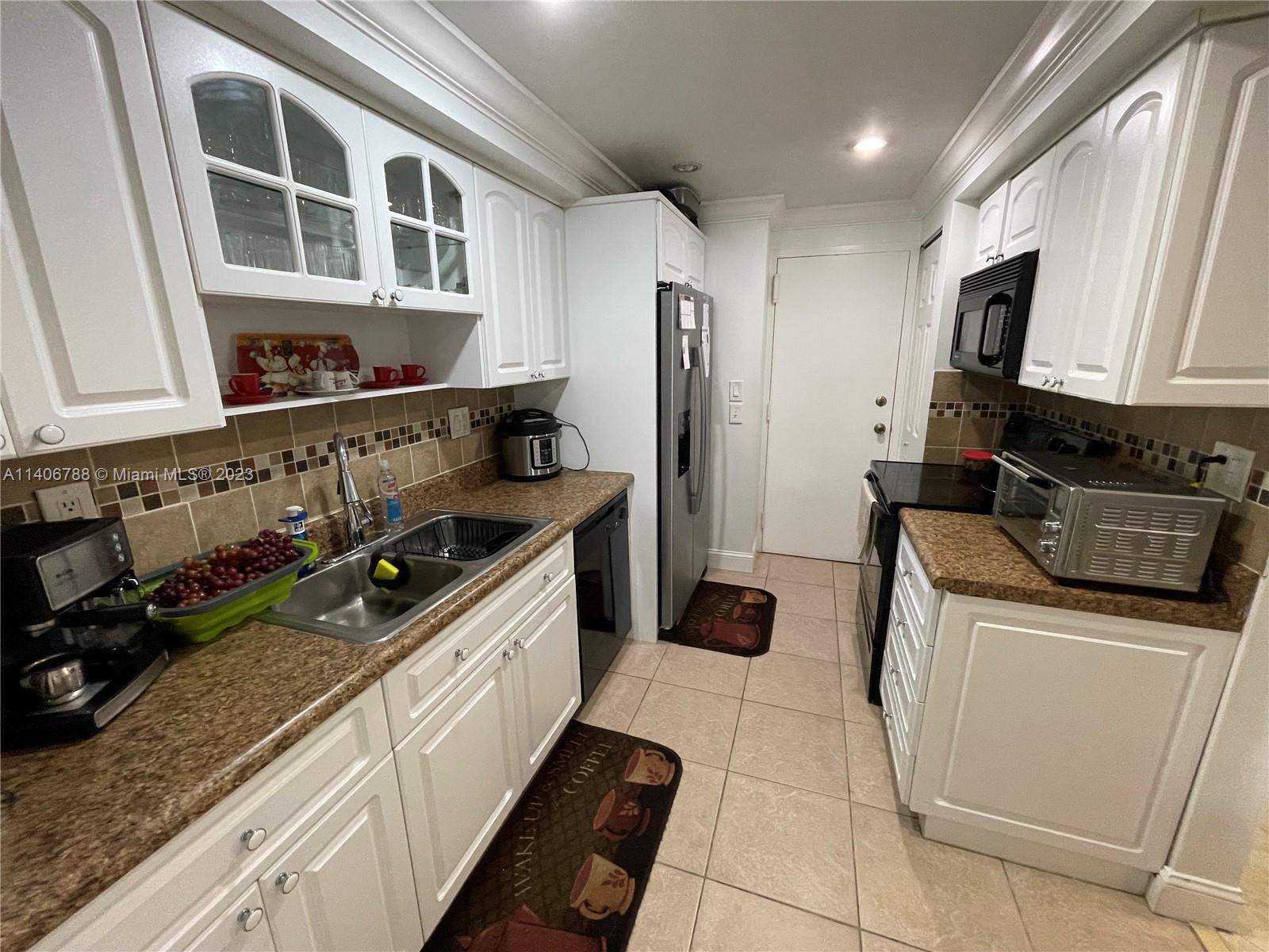 6861 Southwest 147th Avenue, Unit 2G Miami, FL 33193 - Photo 9 of 34 a kitchen with stainless steel appliances a stove a sink and a refrigerator