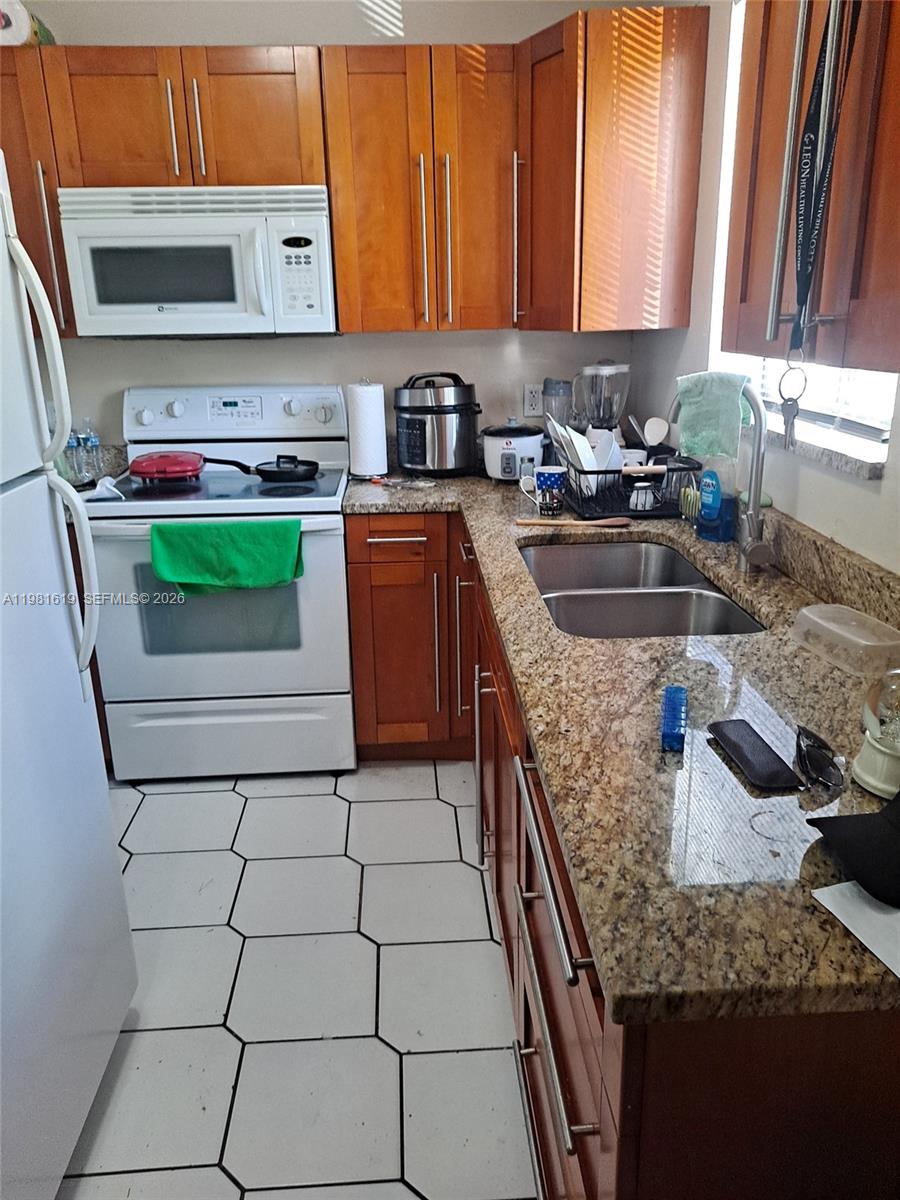 10765 Southwest 4th Street, Unit 1 Sweetwater, FL 33174 - Photo 1 of 6 a kitchen with stainless steel appliances granite countertop a sink stove and cabinets