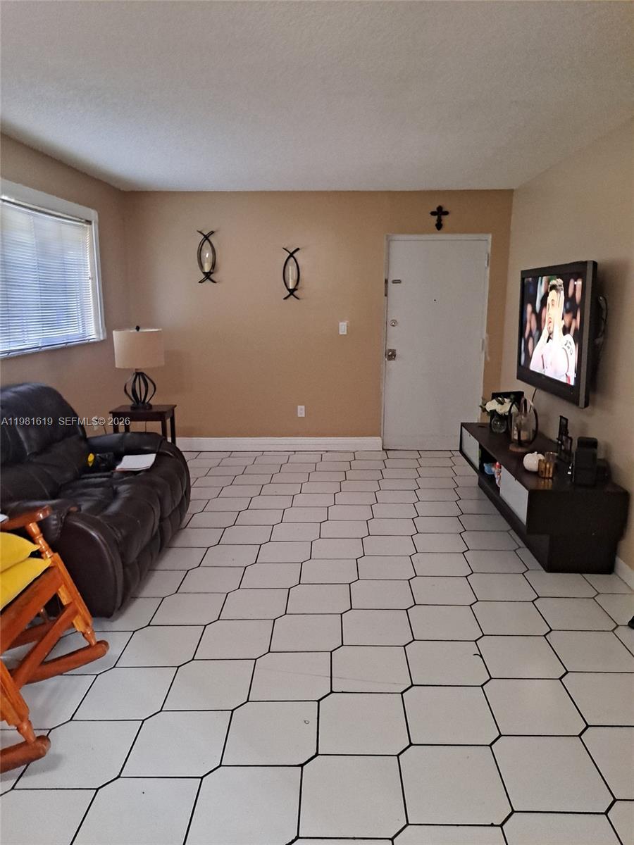 10765 Southwest 4th Street, Unit 1 Sweetwater, FL 33174 - Photo 2 of 6 a living room with a black white checkered floor