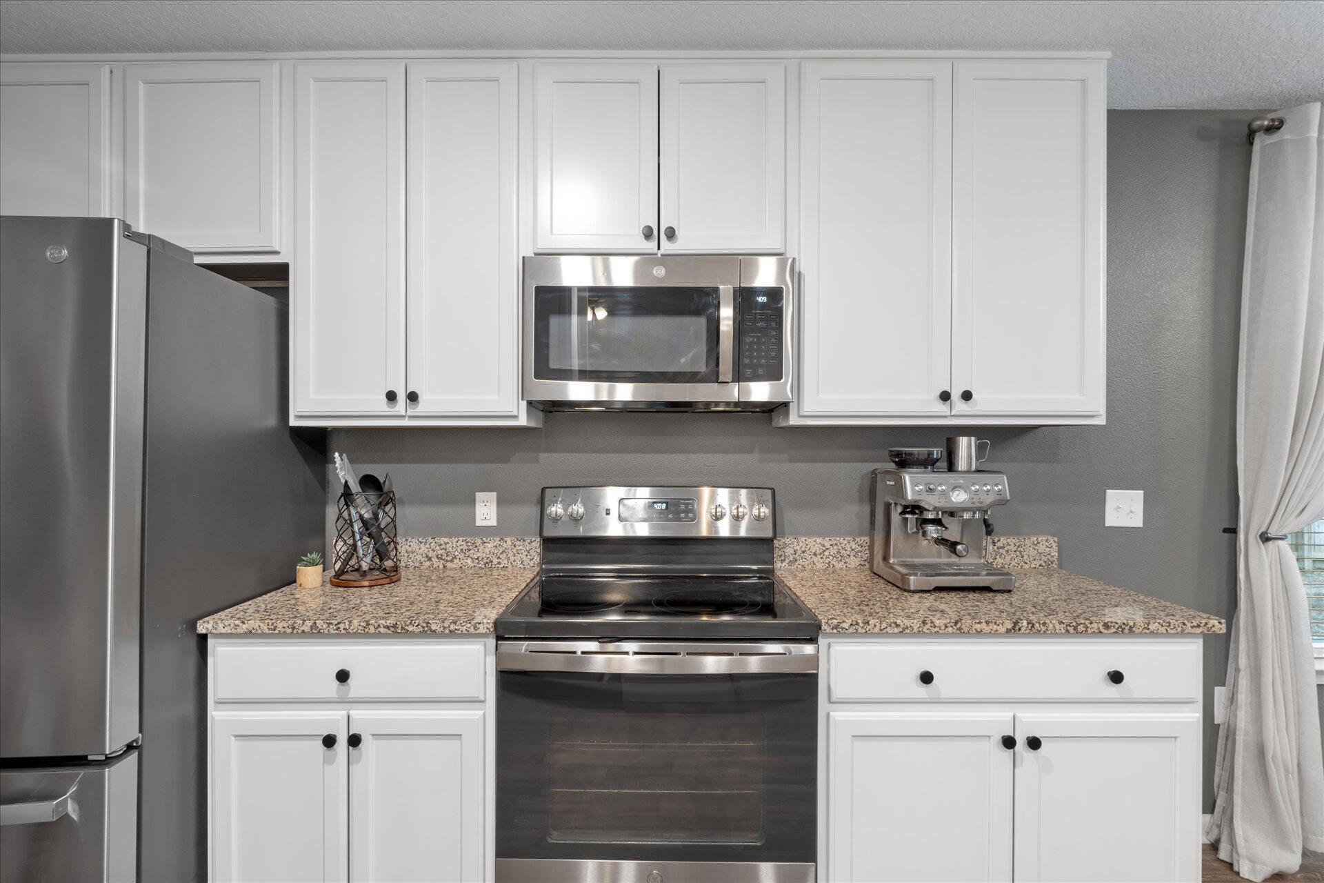 6052 Eden Road Crestview, FL 32539 - Photo 18 of 42 a kitchen with granite countertop white cabinets and stainless steel appliances