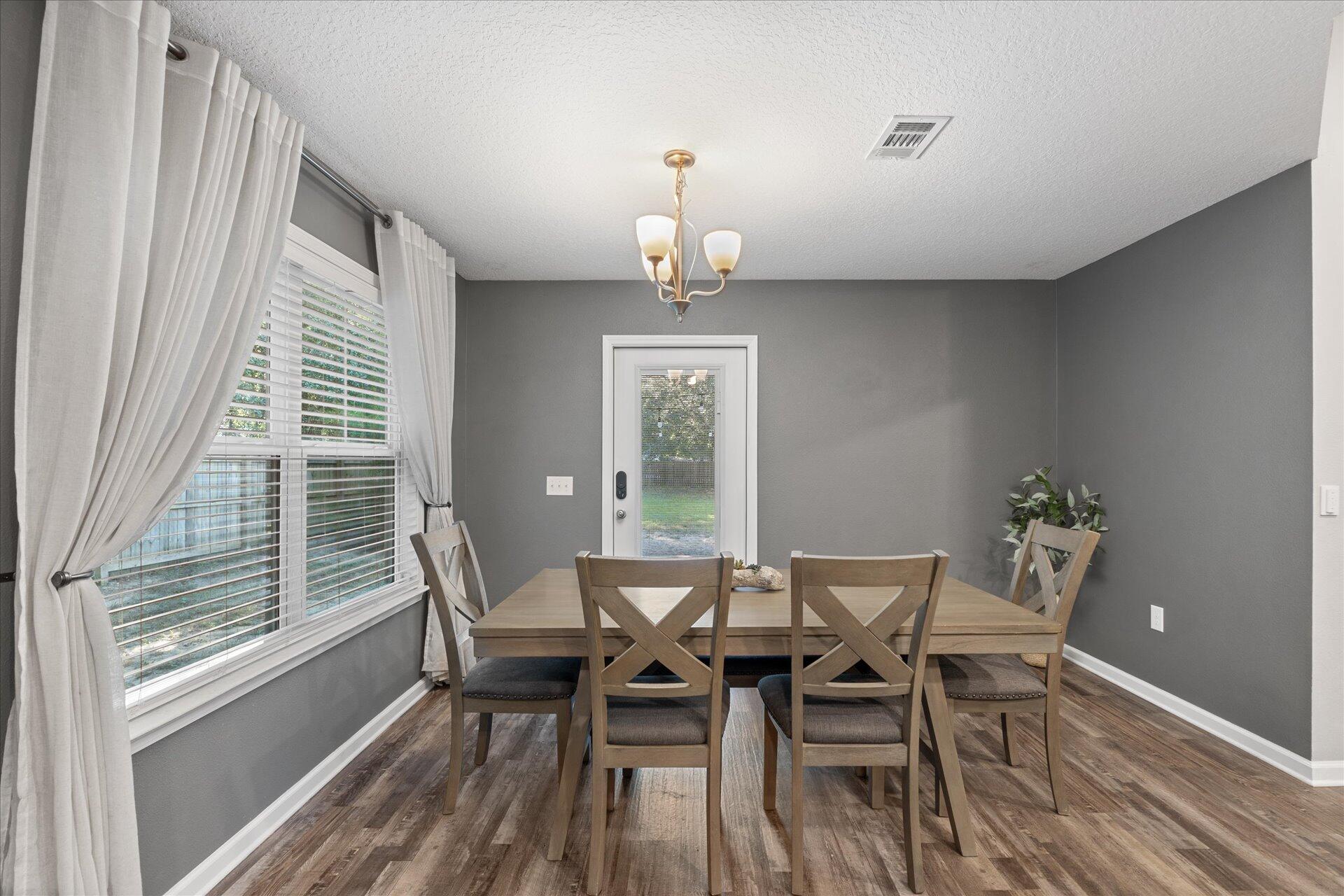 6052 Eden Road Crestview, FL 32539 - Photo 4 of 42 a dining room with furniture a chandelier and wooden floor