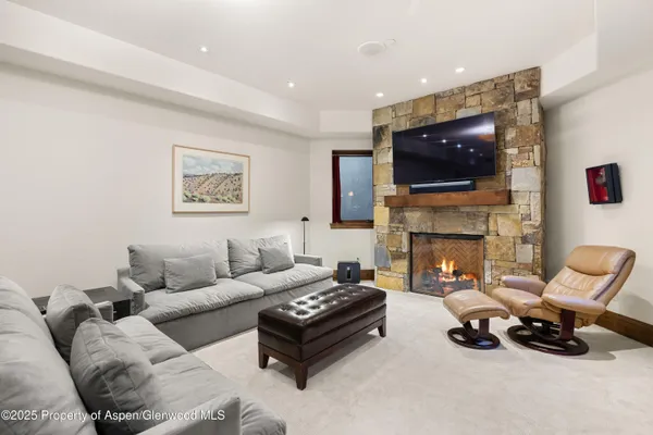 a living room with furniture a flat screen tv and a fireplace