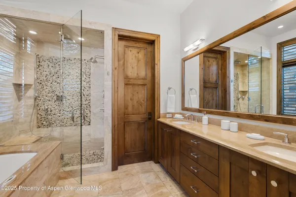 a bathroom with a shower sink and mirror