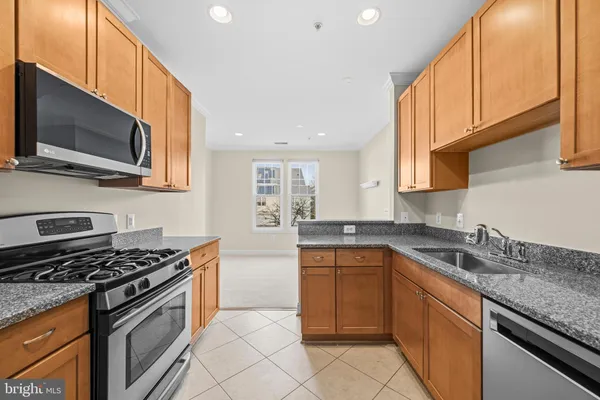 a kitchen with stainless steel appliances granite countertop a sink stove microwave and cabinets