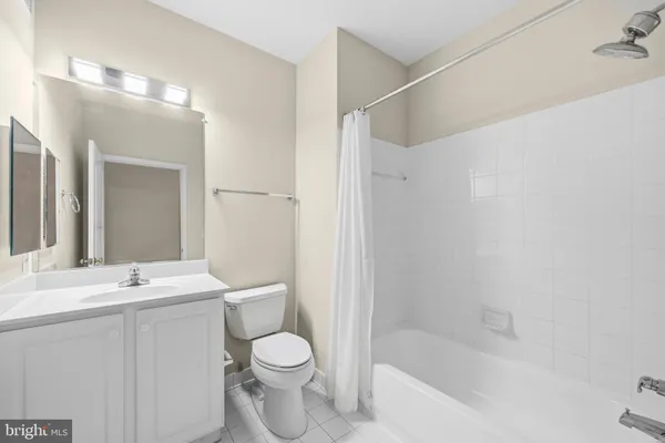 a bathroom with a bathtub shower sink vanity and toilet