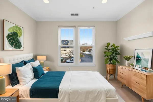 a bedroom with a bed and a large window