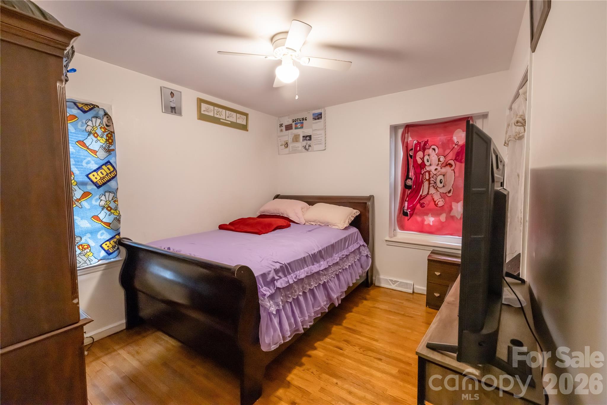 2545 Cedarwild Road Charlotte, NC 28212 - Photo 7 of 25 a bedroom with a bed and a flat screen tv