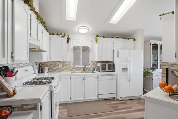 a kitchen with cabinets appliances a sink and a counter top