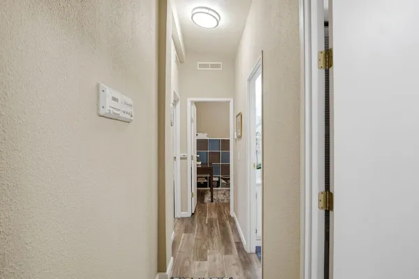 a bedroom with a bed a flat tv screen and a dresser