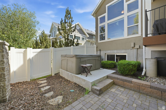 7872 Farm House Lane Midvale, UT 84047 - Photo 33 of 39 Outdoor patio featuring hot tub, pavers and a stone block retaining wall