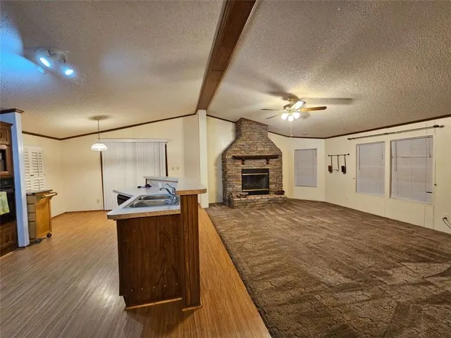 a living room with stainless steel appliances kitchen island granite countertop furniture and a wooden floor