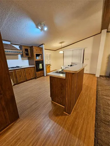 a kitchen with stainless steel appliances wooden floor and wooden cabinets