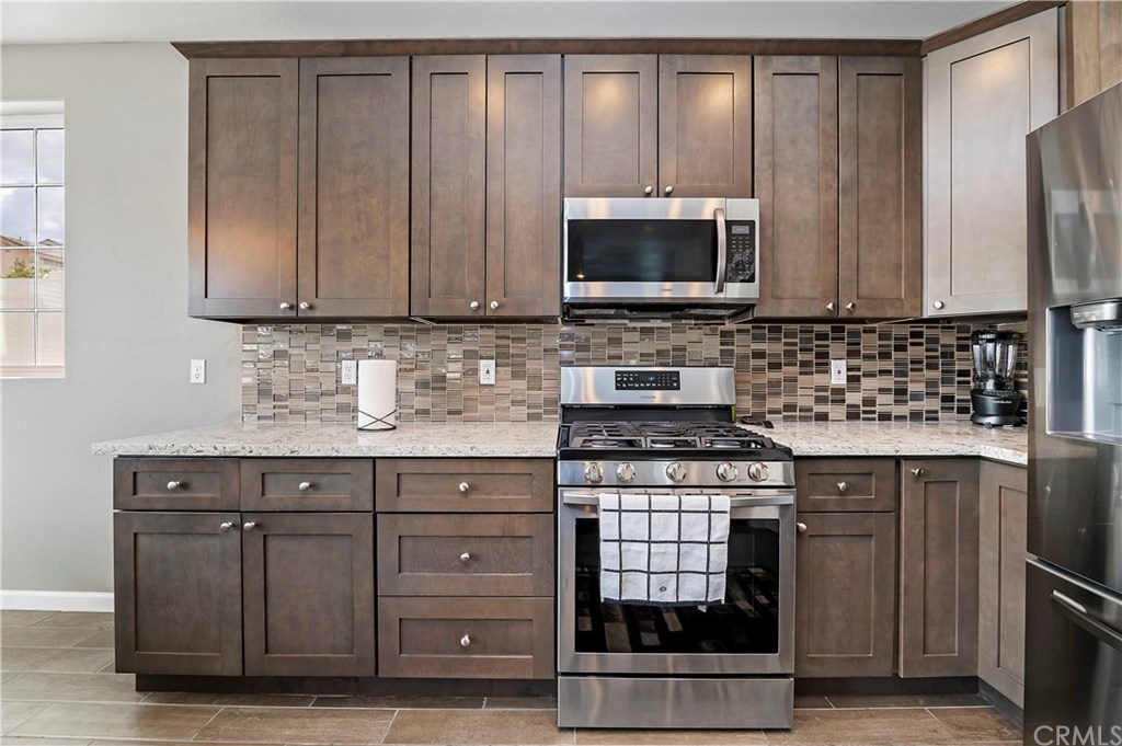 3591 Tyco Drive Riverside, CA 92501 - Photo 17 of 30 a kitchen with stainless steel appliances granite countertop a stove a microwave and a sink
