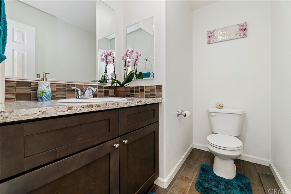 3591 Tyco Drive Riverside, CA 92501 - Photo 27 of 30 a bathroom with a granite countertop toilet sink and mirror