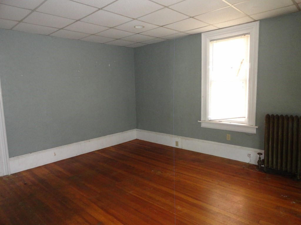 258 Main Street Townsend, MA 01469 - Photo 5 of 23 an empty room with wooden floor and windows