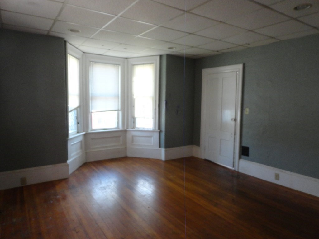 258 Main Street Townsend, MA 01469 - Photo 6 of 23 an empty room with wooden floor and windows