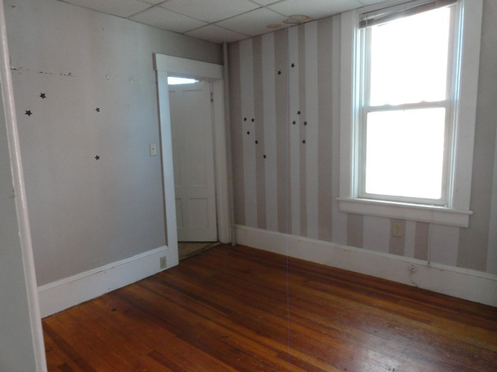 258 Main Street Townsend, MA 01469 - Photo 8 of 23 an empty room with wooden floor and windows