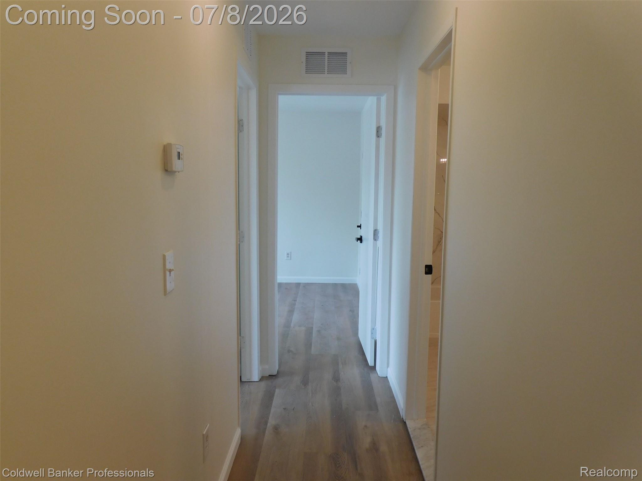 284 East 13 Mile Road Madison Heights, MI 48071 - Photo 11 of 21 Hallway featuring wood-finish flooring, white trim, and light neutral wall paint