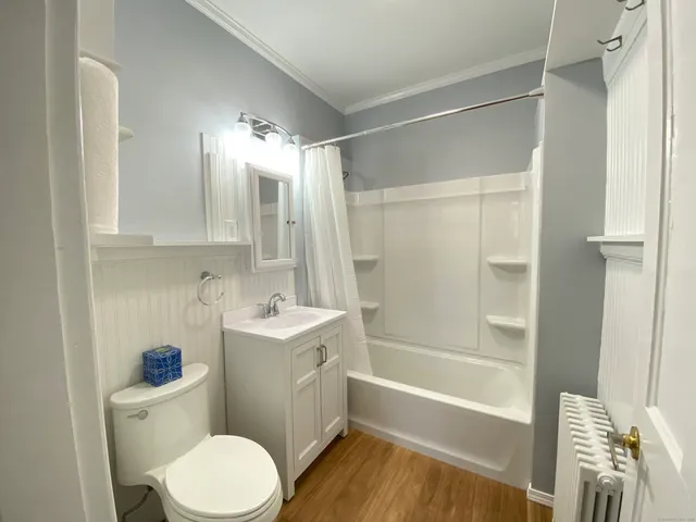 a bathroom with a sink a toilet a mirror a bathtub and shower