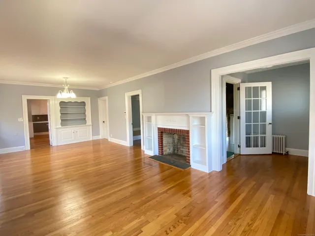 an empty room with wooden floor and fireplace