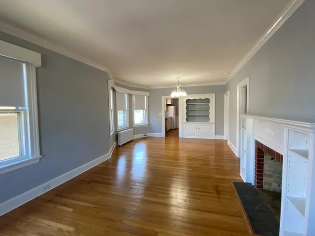 a view of empty room with wooden floor and fireplace