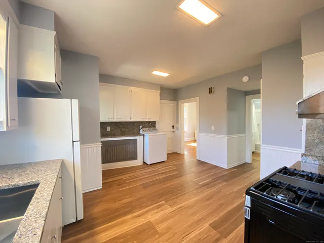 a kitchen with a refrigerator and a stove top oven