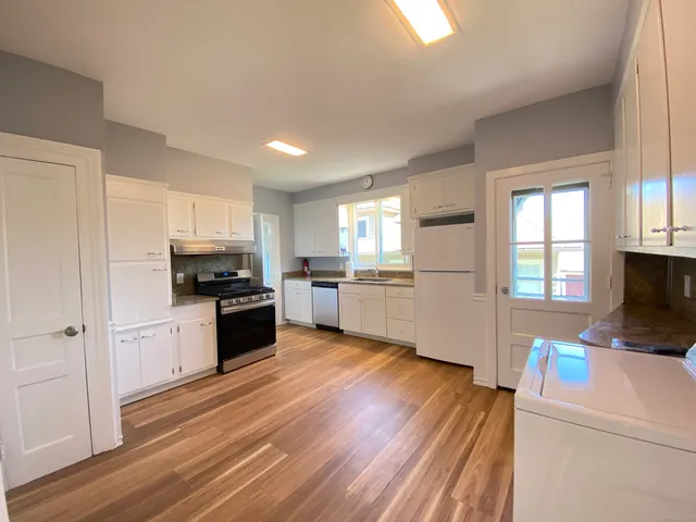 a kitchen with a refrigerator and a stove top oven