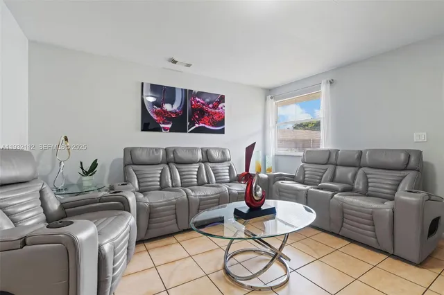 a living room with furniture a rug and a window