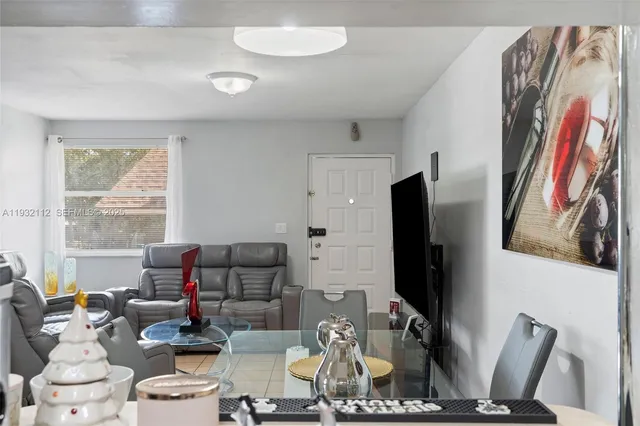a living room with furniture a flat screen tv and a window