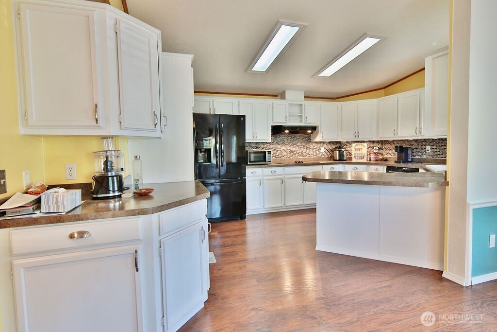 161 Fircrest Drive Sequim, WA 98382 - Photo 14 of 33 a kitchen with stainless steel appliances granite countertop a sink dishwasher a refrigerator a stove oven and white cabinets with wooden floors