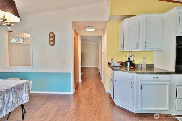a kitchen with granite countertop a sink cabinets and wooden floor