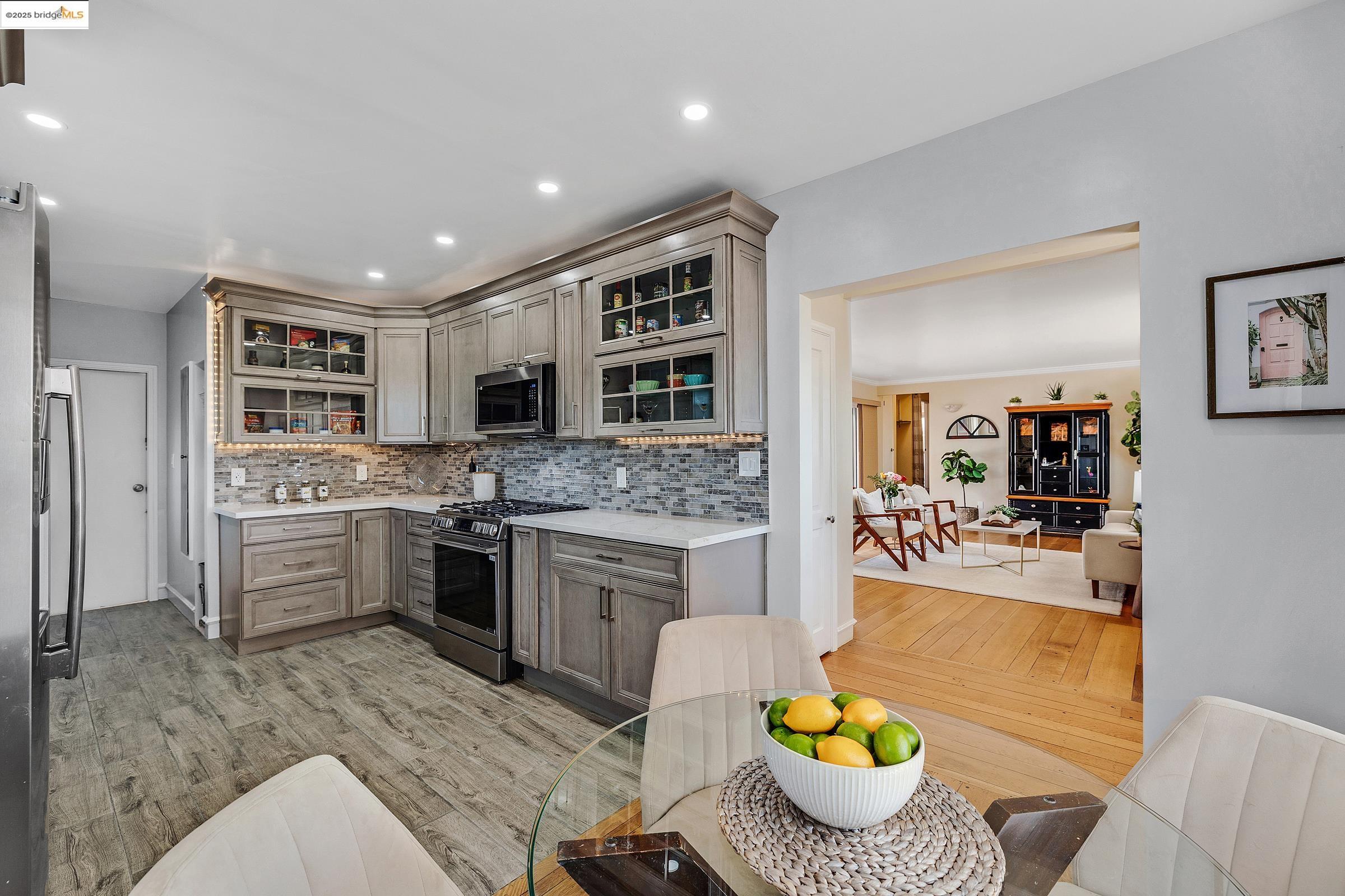 1034 Navellier Street El Cerrito, CA 94530 - Photo 18 of 57 Kitchen with stainless steel appliances, backsplash, gray cabinets, glass insert cabinets, and light wood-style flooring