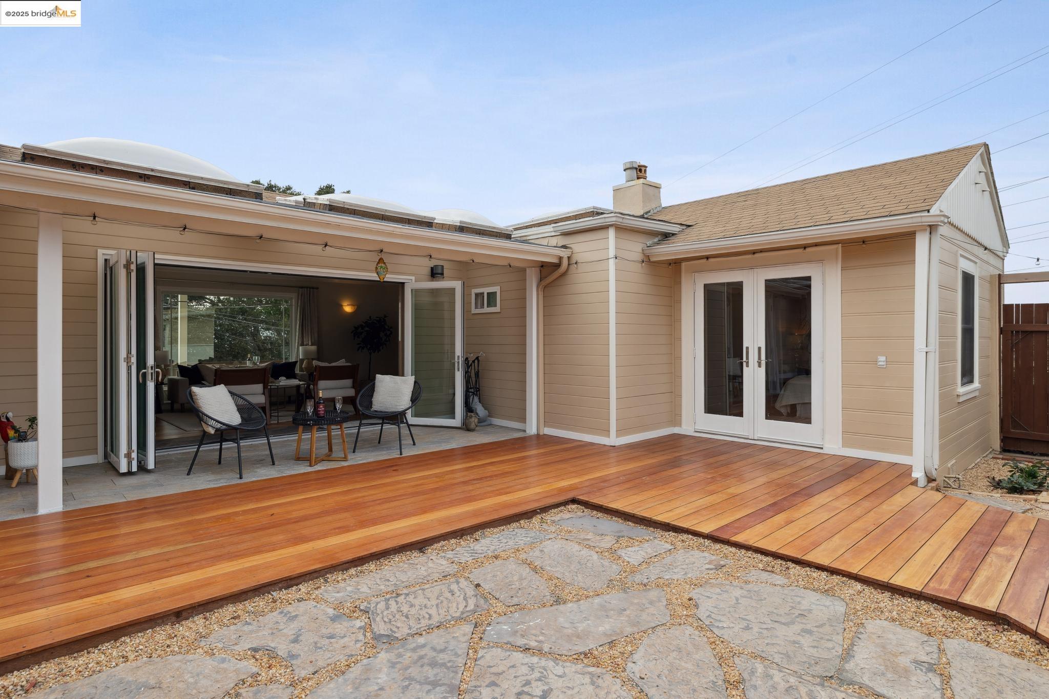 1034 Navellier Street El Cerrito, CA 94530 - Photo 50 of 57 Back of property featuring french doors, a wooden deck, a chimney, and a shingled roof
