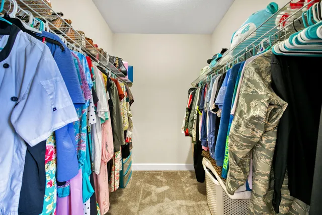 a view of walk in closet with clothes