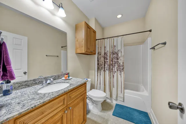 a bathroom with a granite countertop sink toilet and shower