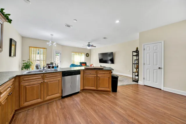 a large kitchen with cabinets wooden floor and stainless steel appliances