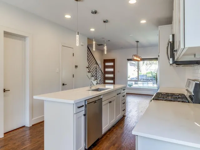 a kitchen with a sink stove and wooden floor