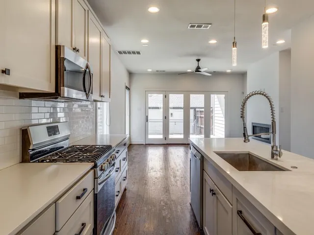 a kitchen with stainless steel appliances a sink stove and cabinets