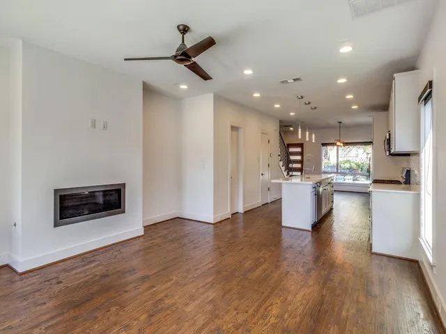 a view of a living room a kitchen with wooden floor and a kitchen