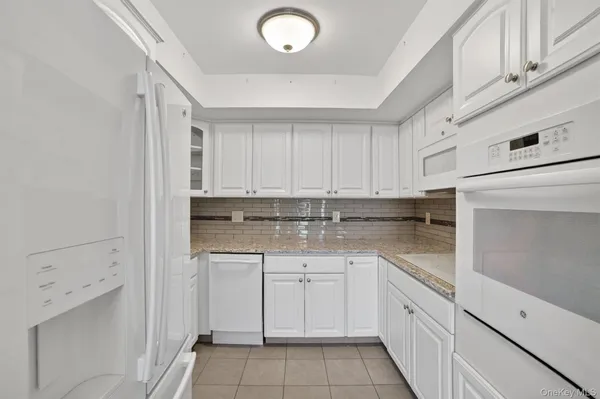 a kitchen with white cabinets appliances and sink