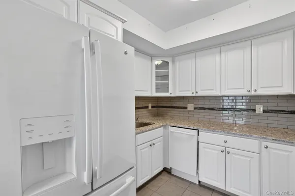 a kitchen with white cabinets and white appliances