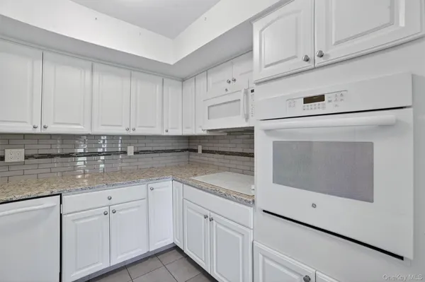 a kitchen with white cabinets and white appliances